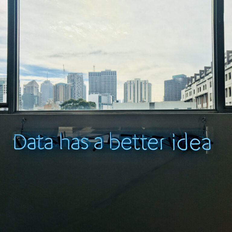 Neonschild an Wand mit Stadt im Hintergrund Daten & Digitalisierung